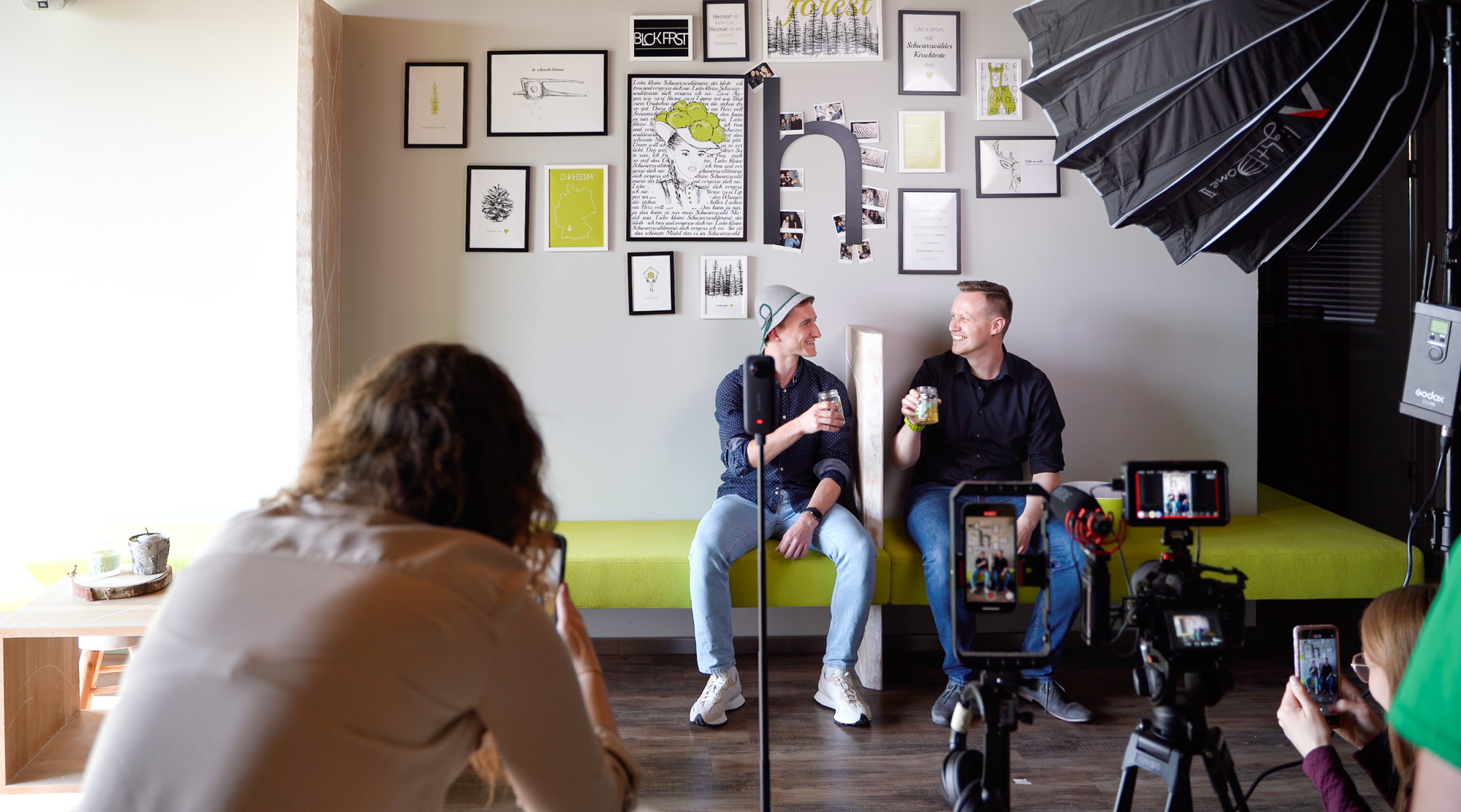 Interview-Dreh bei hitcom: zwei Markenbotschafter auf der Bank, das Team filmt mit