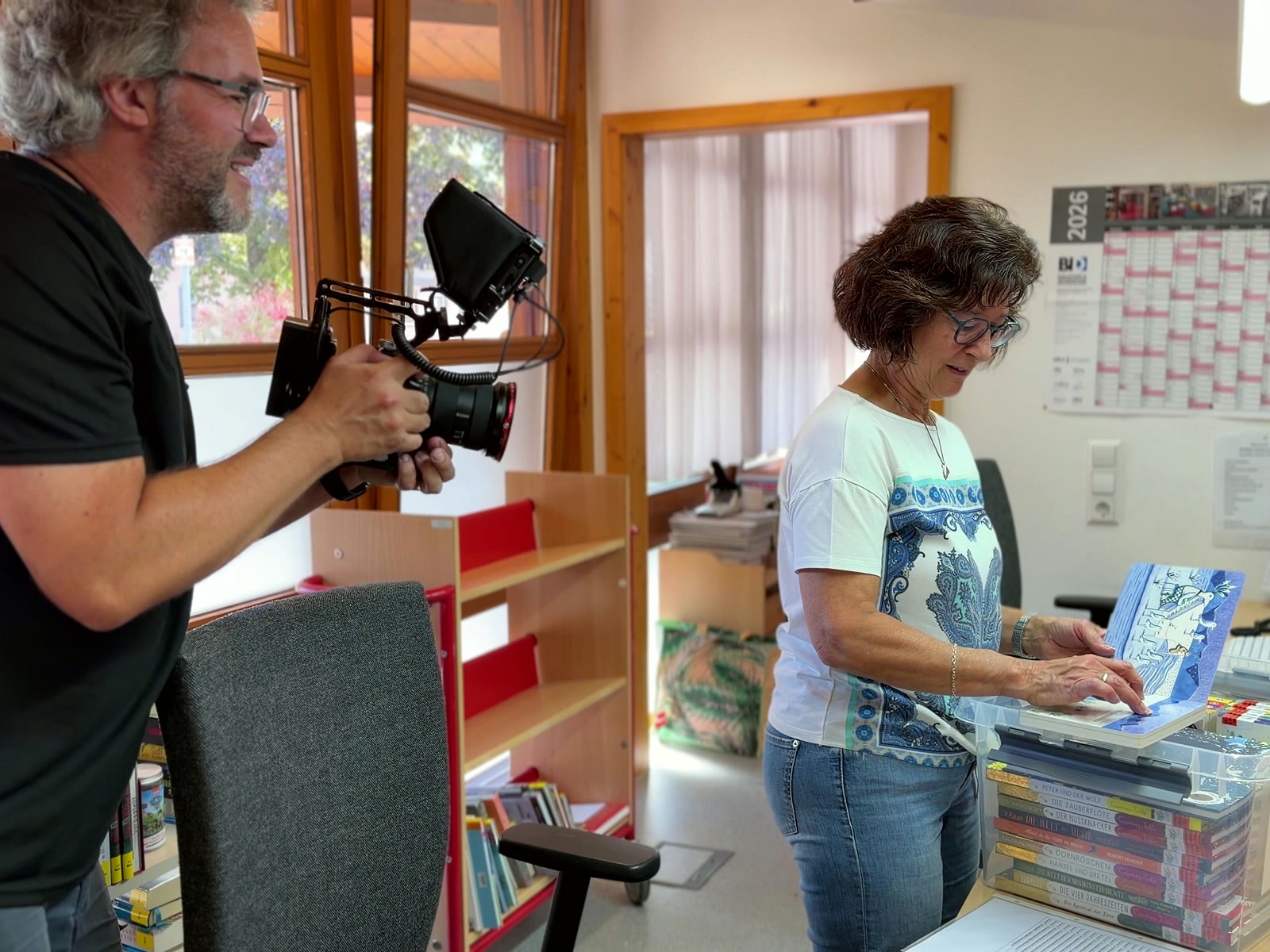 Arne Kocher filmt eine Büchereileiterin an der Theke