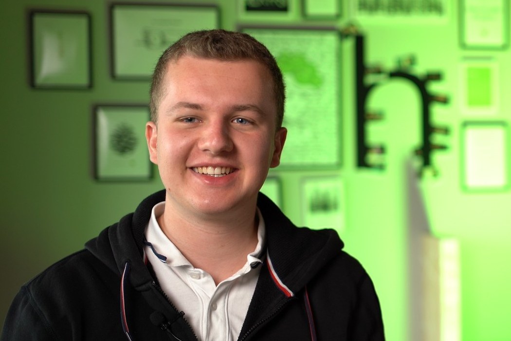Junger Mitarbeiter von hitcom lacht in die Kamera, Mitarbeiter-Testimonial aus dem Recruiting-Film