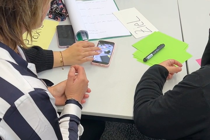 Teilnehmerin im Videopraxis-Workshop in Horb arbeitet mit Notizen und Smartphone an ihrer Videoidee