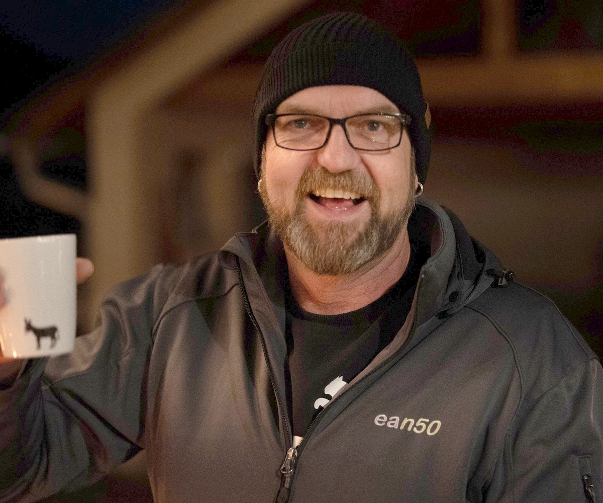 ean50-Jubiläum an der Eselsmühle: Mitarbeiter in ean50-Jacke lacht mit Tasse in die Kamera