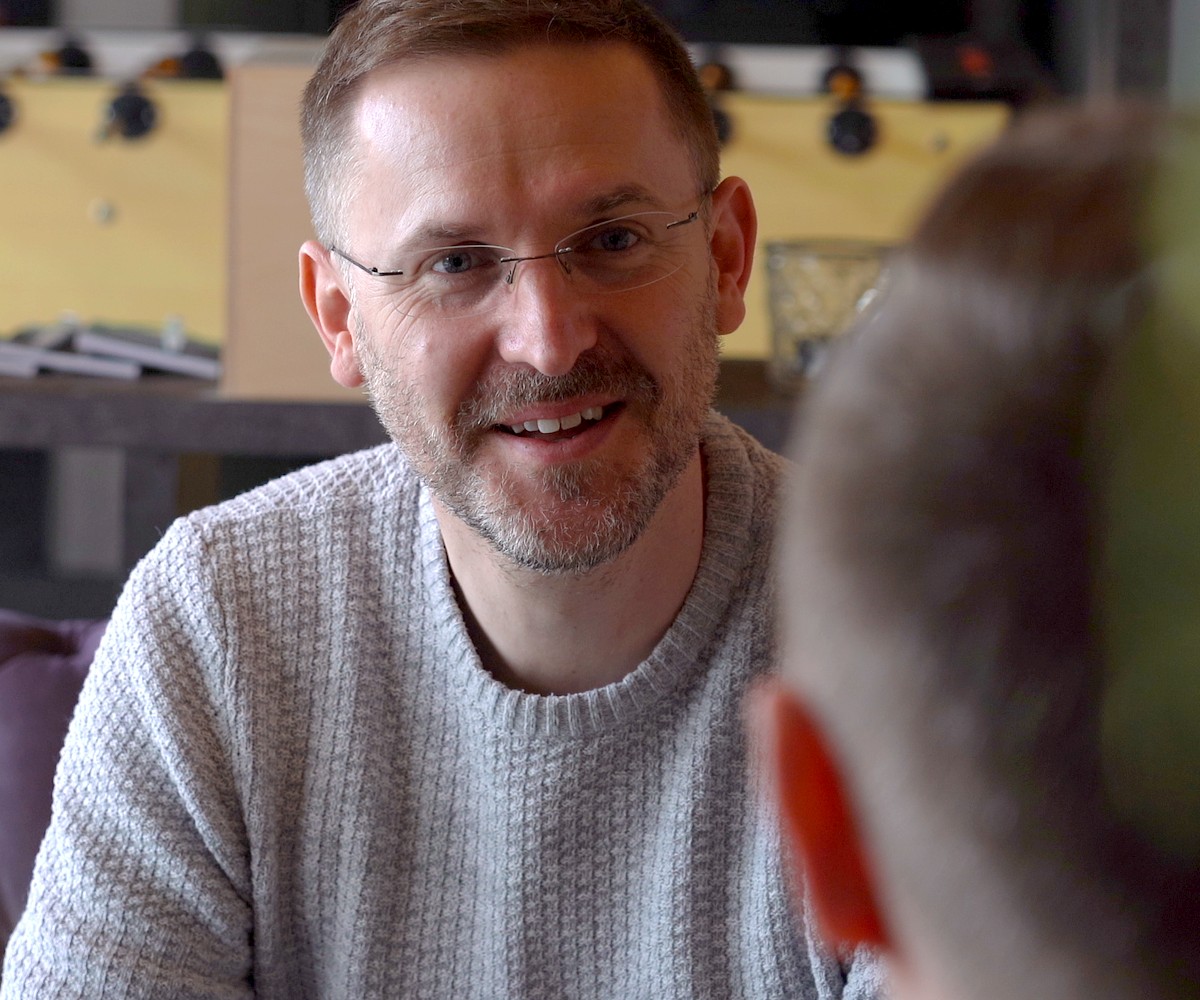 Recruiting-Film hitcom: Mitarbeiter lächelt im Gespräch im Besprechungsraum