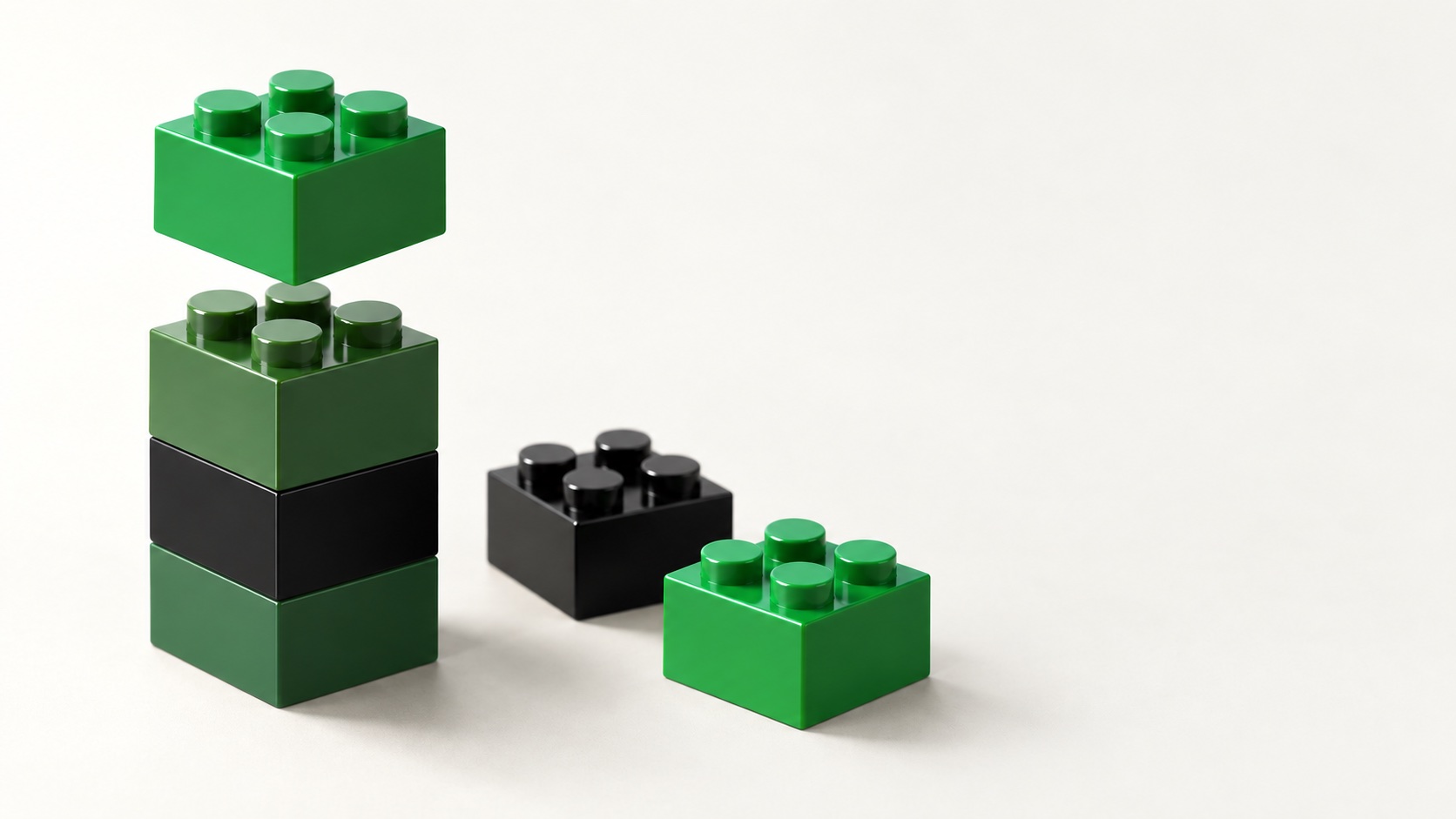 Grüne und schwarze Bausteine, ein Stein wird gerade auf einen Turm gesteckt